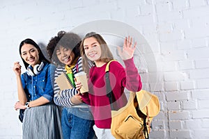 portrait of smiling multiracial students standing against white