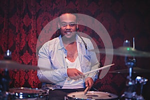 Portrait of smiling musician playing drum kit