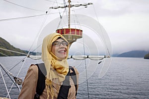 Portrait of smiling muslim woman on Hakone sightseeing cruise ship at Lake Ashi with happy expression.