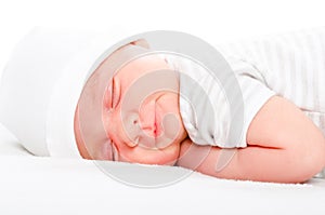 Portrait of a smiling newborn sleeping baby