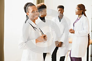 Portrait of a smiling nurse in front of her medical team.