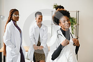 Portrait of a smiling nurse in front of her medical team.