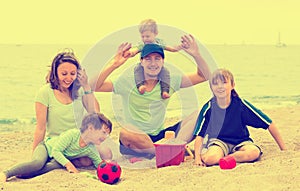Portrait of smiling parents and their children on sand