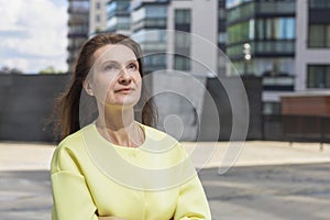 Portrait of smiling pensive middle aged woman. elderly businesswoman near business center. lecturer, teacher