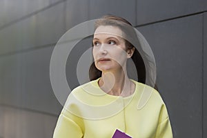 Portrait of smiling pensive middle aged woman. elderly businesswoman near business center. lecturer, teacher