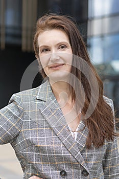 Portrait of smiling pensive middle aged woman. elderly businesswoman near business center. lecturer, teacher