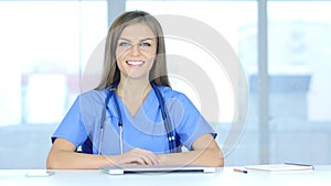 Portrait of Smiling Positive Female Doctor Sitting in Clinic