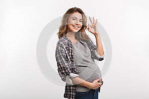 portrait of smiling pregnant woman showing ok sign