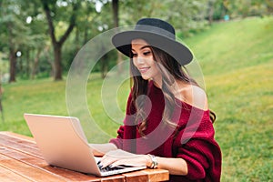 Portrait of a smiling pretty asian girl using laptop computer