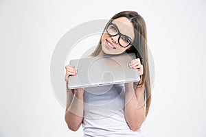 Portrait of a smiling pretty girl holding laptop