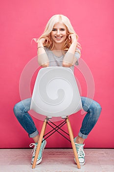 Portrait of a smiling pretty woman sitting on the chair