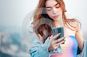 Portrait of smiling pretty young  woman using phone on rooftop city bangkok.Female using mobile phone make vlog and live in social