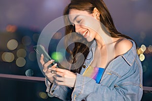 Portrait of smiling pretty young  woman using phone on rooftop city bangkok.Female using mobile phone make vlog and live in social