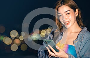 Portrait of smiling pretty young  woman using phone on rooftop city bangkok.Female using mobile phone make vlog and live in social