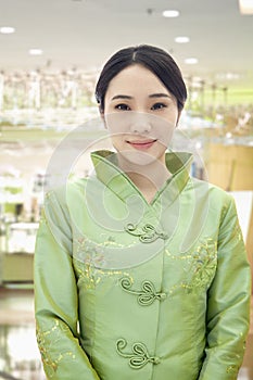 Portrait of Smiling Restaurant/Hotel Hostess in Traditional Chinese Clothing in the Restaurant