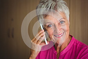 Portrait of a smiling retired woman making a call