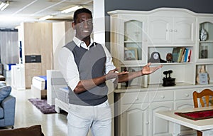 Portrait of smiling salesman who is offering modern furniture