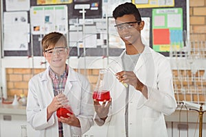 Portrait of smiling school kids doing a chemical experiment in laboratory