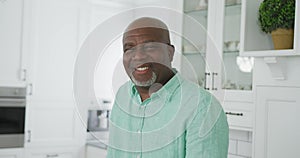 Portrait of smiling senior african american man looking at camera in kitchen
