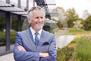 Portrait Of Smiling Senior Businessman CEO Chairman Standing Outside Modern Office Building