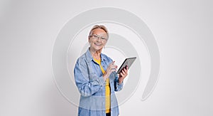 Portrait of smiling senior female professional working over digital tablet over white background