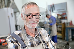 Portrait of smiling senior ironworker in workshop photo