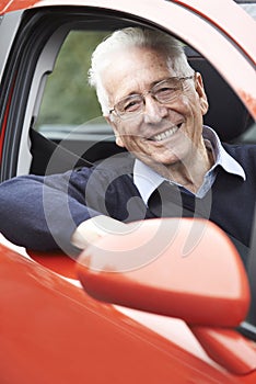 Portrait Of Smiling Senior Man Driving Car