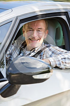 Portrait Of Smiling Senior Man Driving Car