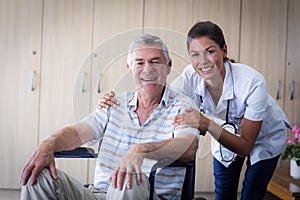 Portrait of smiling senior man and female doctor in living room