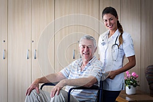 Portrait of smiling senior man and female doctor in living room