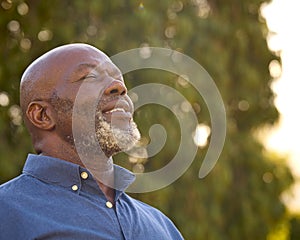 Portrait Of Smiling Senior Man Outdoors In Countryside Relaxing Closing Eyes And Taking Deep Breaths photo