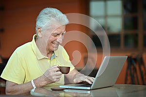 Portrait of smiling senior man using laptop