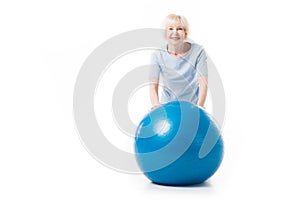 Portrait of smiling senior sportswoman with fitness ball