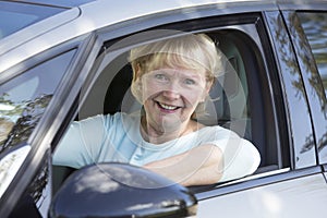 Portrait Of Smiling Senior Woman Driving Car