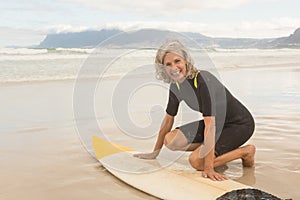 Portrait of smiling senior woman preparing for surfboarding