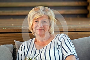 Portrait of a smiling senior woman sitting on a sofa at home