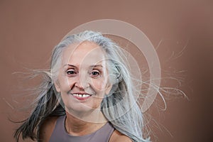 Portrait of smiling senior woman in studio.