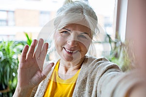 Portrait of smiling senior woman taking selfie