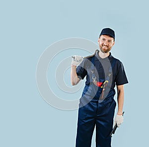 Portrait of a smiling service worker holding tools, dressed in uniform