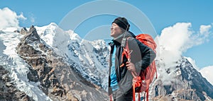 Portrait of smiling Sherpa man with backpack enjoying mountain views and fresh air with Mera peak 6476m background. High Himalayas