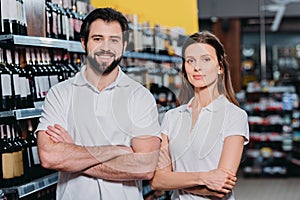portrait of smiling shop assistants with arms crossed photo