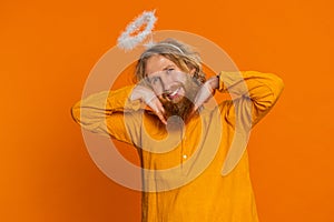 Portrait of smiling shy angelic Caucasian man with angel halo nimb over head positive love emotions