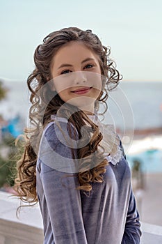 Portrait of a smiling sly naughty girl with curlers in an old retro dress