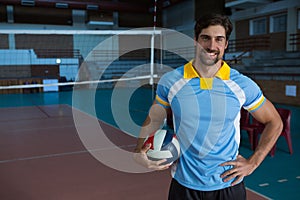 Portrait of smiling sportsperson holding volleyball