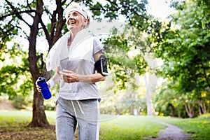 Portrait of smiling sporty senior woman with towel outdoor