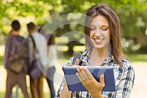 Portrait of a smiling student with a shoulder bag and using tablet computer