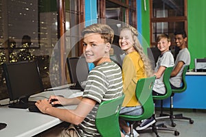 Portrait of smiling students studying in computer classroom