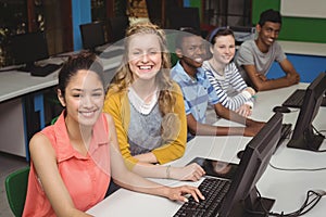 Portrait of smiling students studying in computer classroom