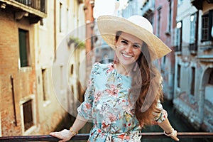 Portrait of smiling stylish traveller woman in floral dress