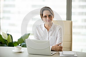 Portrait of smiling successful businesswoman posing at office de